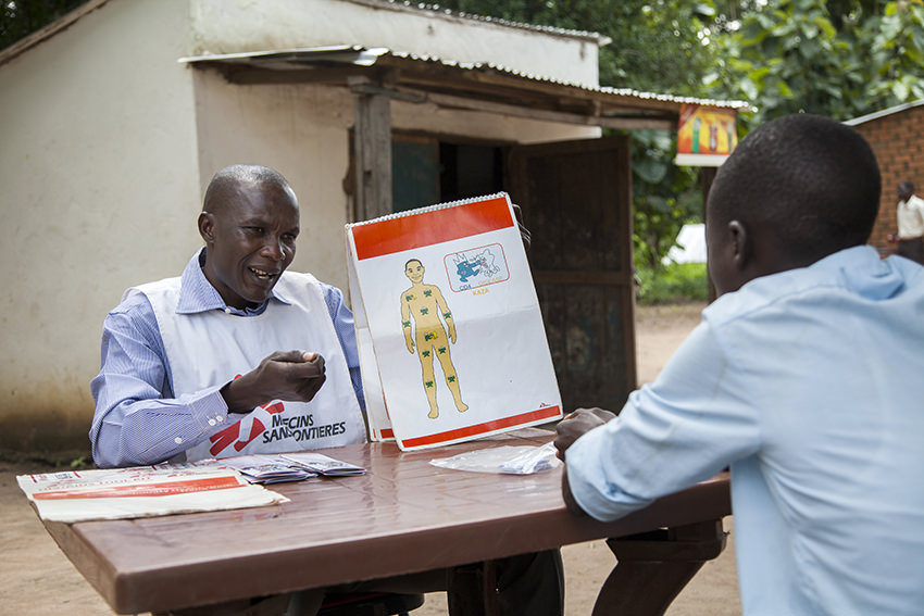 Ein Mitarbeiter der Hilfsorganisation Ärzte ohne Grenzen (MSF) erklärt einem interessierten Patienten in Nambiri im Südsudan vor dem Test die Grundlagen des Wirkens des HI-Virus im Körper. © dpa